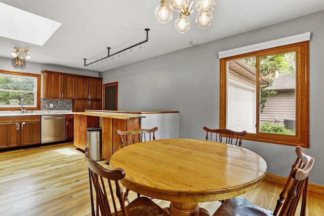 4705 Winnequah Rd, Monona, WI 53716 - dining space with light wood finished floors, a skylight, and a chandelier