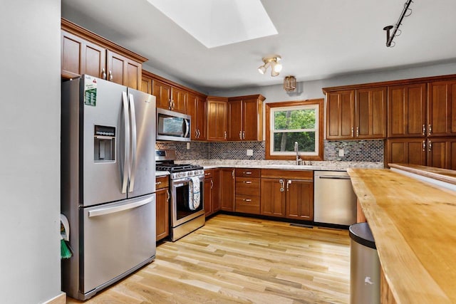 4705 Winnequah Rd, Monona, WI 53716 - kitchen featuring appliances with stainless steel finishes, a sink, wood counters, light wood-style flooring, and backsplash