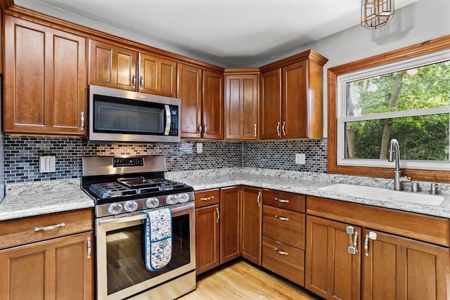 4705 Winnequah Rd, Monona, WI 53716 - kitchen featuring appliances with stainless steel finishes, a sink, backsplash, and brown cabinets