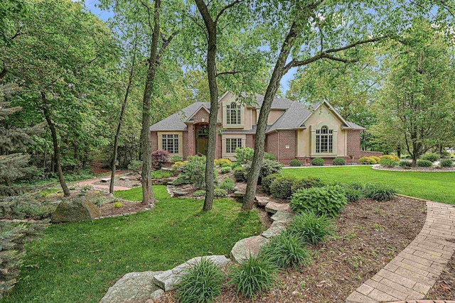 705 Red Fox, Fond Du Lac, WI 54937 - view of front of house featuring brick siding, a front yard, and stucco siding