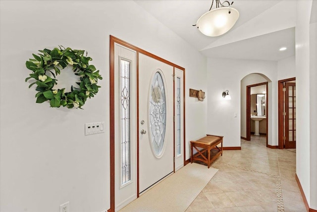 7197 Welford Pl, Sun Prairie, WI 53590 - foyer with arched walkways, baseboards, lofted ceiling, and light tile patterned floors