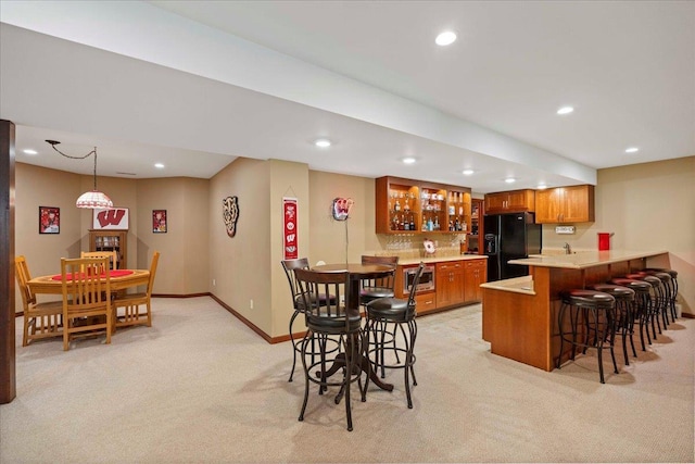 7197 Welford Pl, Sun Prairie, WI 53590 - dining room featuring wet bar, light colored carpet, recessed lighting, and baseboards