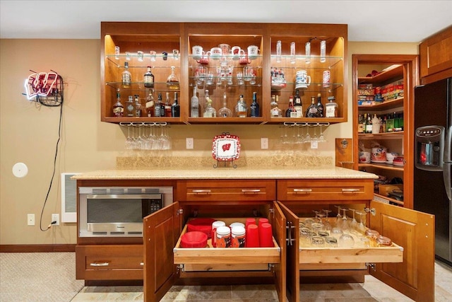 7197 Welford Pl, Sun Prairie, WI 53590 - indoor dry bar with black fridge, stainless steel microwave, and baseboards