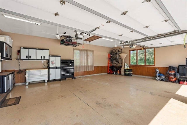 7197 Welford Pl, Sun Prairie, WI 53590 - garage with wood walls, a wainscoted wall, and a garage door opener