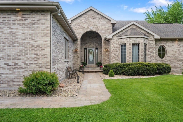 7197 Welford Pl, Sun Prairie, WI 53590 - property entrance featuring a lawn, brick siding, and a shingled roof