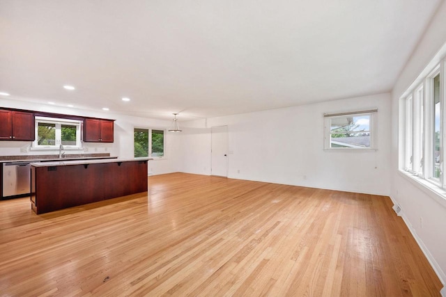 109 Cherry St, Edgerton, WI 53534 - kitchen with open floor plan, stainless steel dishwasher, light wood finished floors, a sink, and a center island