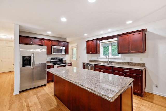 109 Cherry St, Edgerton, WI 53534 - kitchen featuring appliances with stainless steel finishes, a sink, reddish brown cabinets, a kitchen island, and recessed lighting