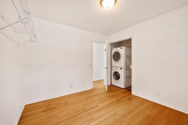 109 Cherry St, Edgerton, WI 53534 - washroom with stacked washer / drying machine, light wood-style flooring, and baseboards