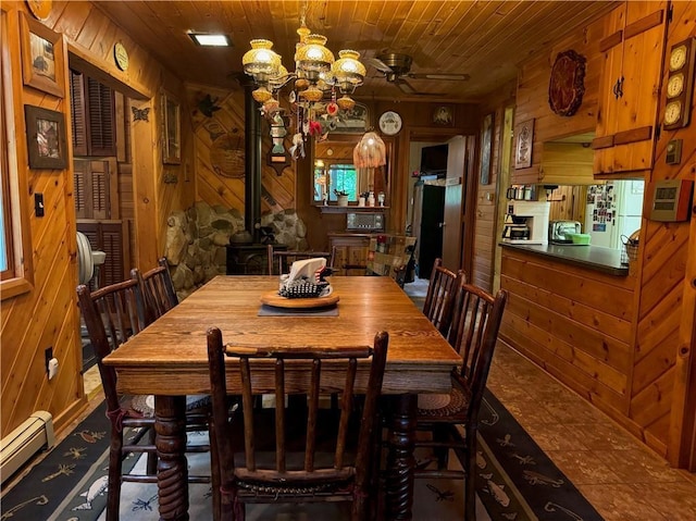 16199 W Musky Point Dr, Stone Lake, WI 54843 - tiled dining space featuring wood walls, baseboard heating, wood ceiling, ceiling fan, and a chandelier