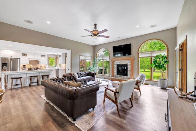 8373 Serenity Ln, Pulaski, WI 54162 - living area with a ceiling fan, plenty of natural light, a fireplace, light wood-style floors, and recessed lighting