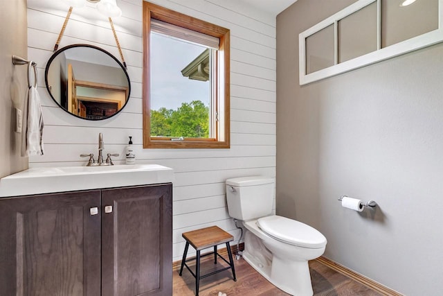 8373 Serenity Ln, Pulaski, WI 54162 - bathroom with toilet, wooden walls, wood finished floors, and vanity