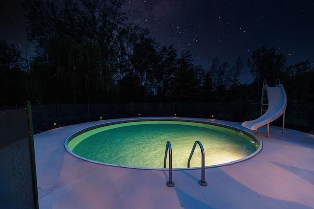 8373 Serenity Ln, Pulaski, WI 54162 - pool at night featuring a water slide and a patio area