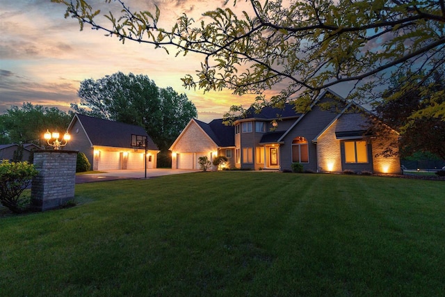8373 Serenity Ln, Pulaski, WI 54162 - back of house at dusk with a yard, an outbuilding, driveway, and brick siding