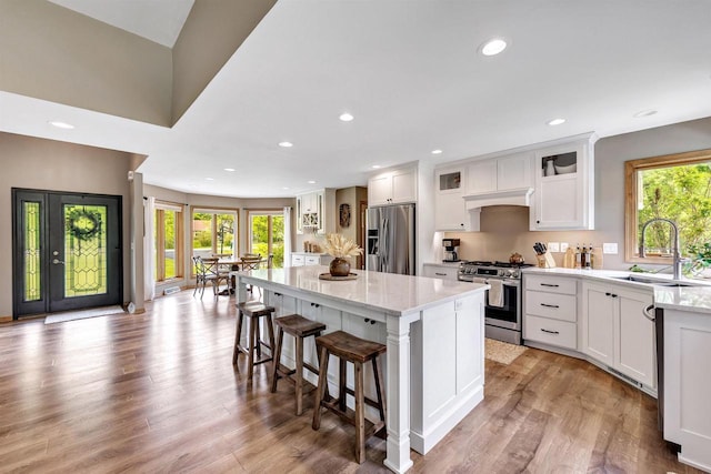 8373 Serenity Ln, Pulaski, WI 54162 - kitchen featuring appliances with stainless steel finishes, a sink, a kitchen island, white cabinetry, and recessed lighting