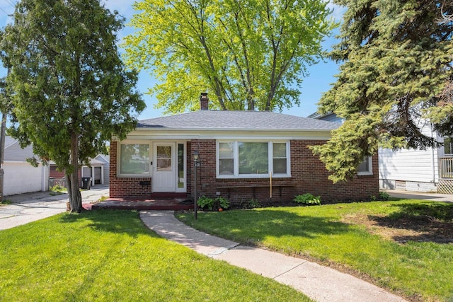 3559 E Van Norman Ave, Cudahy, WI 53110 - view of front of home featuring brick siding, a chimney, a front lawn, and an outbuilding