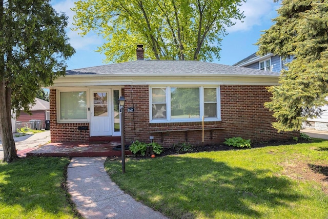 3559 E Van Norman Ave, Cudahy, WI 53110 - view of front of house featuring brick siding, a front yard, and a chimney