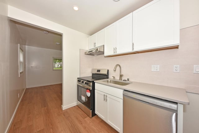 4212 N 53rd St, Milwaukee, WI 53216 - kitchen featuring stainless steel appliances, a sink, backsplash, light wood-style flooring, and under cabinet range hood