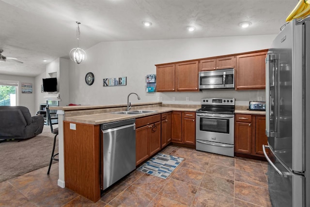 1308 Lavender Ln, Appleton, WI 54915 - kitchen with stainless steel appliances, a sink, lofted ceiling, open floor plan, and brown cabinetry