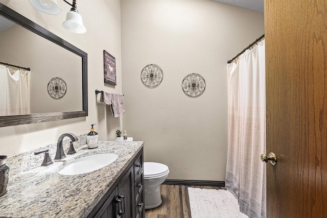 W7009 Crestwood Ln, Fond Du Lac, WI 54937 - bathroom with toilet, vanity, wood finished floors, baseboards, and curtained shower
