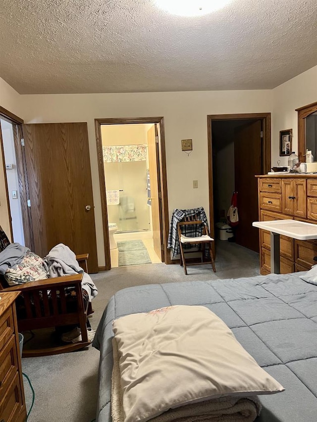 2335 Granite Ter Unit 32, Beloit, WI 53511 - bedroom featuring light colored carpet, a textured ceiling, and ensuite bath
