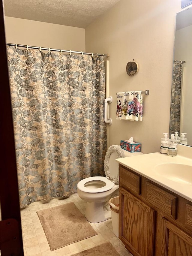 2335 Granite Ter Unit 32, Beloit, WI 53511 - bathroom featuring vanity, a textured ceiling, toilet, tile patterned floors, and a shower with shower curtain