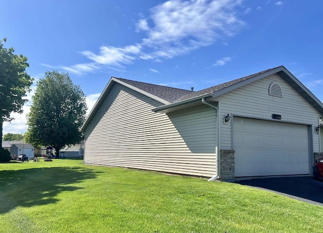 2335 Granite Ter Unit 32, Beloit, WI 53511 - view of home's exterior with a shingled roof, a yard, asphalt driveway, and a garage