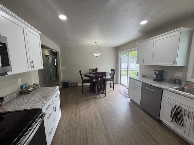1040 S Park St, Shawano, WI 54166 - kitchen with appliances with stainless steel finishes, recessed lighting, dark wood finished floors, white cabinetry, and a sink