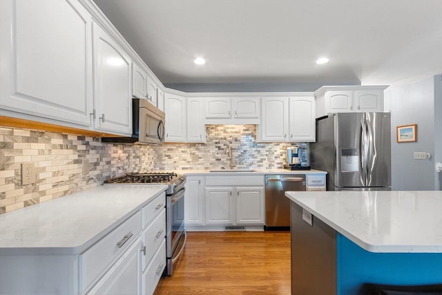 1243 Pond View Cir, De Pere, WI 54115 - kitchen featuring stainless steel appliances, white cabinetry, a sink, tasteful backsplash, and recessed lighting