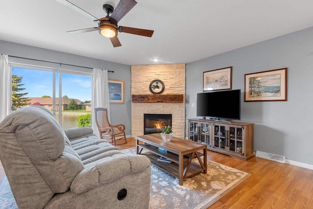 1243 Pond View Cir, De Pere, WI 54115 - living room featuring a ceiling fan, baseboards, a stone fireplace, and wood finished floors