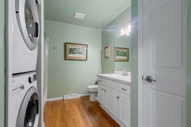 1243 Pond View Cir, De Pere, WI 54115 - bathroom with stacked washer and clothes dryer, toilet, vanity, wood finished floors, and a shower with shower curtain