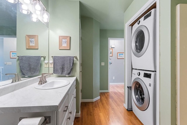 1243 Pond View Cir, De Pere, WI 54115 - bathroom with stacked washing machine and dryer, wood finished floors, vanity, and baseboards