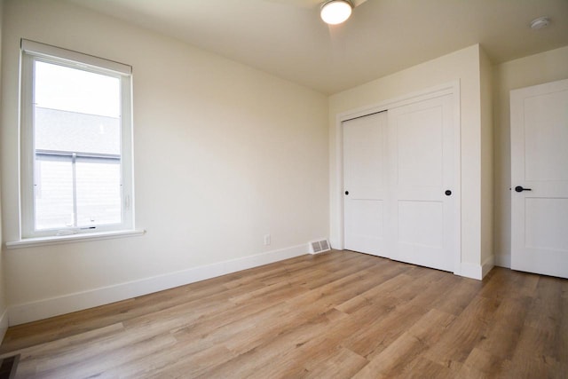 4200 E Lake Vista Blvd, Oak Creek, WI 53154 - unfurnished bedroom with multiple windows, baseboards, light wood-style floors, and a closet