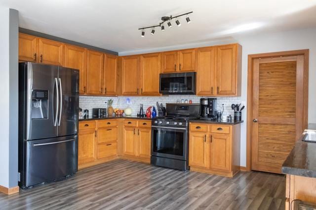 516 Prairie Point Dr, Poplar Grove, IL 61065 - kitchen with appliances with stainless steel finishes, dark countertops, dark wood-style flooring, and tasteful backsplash
