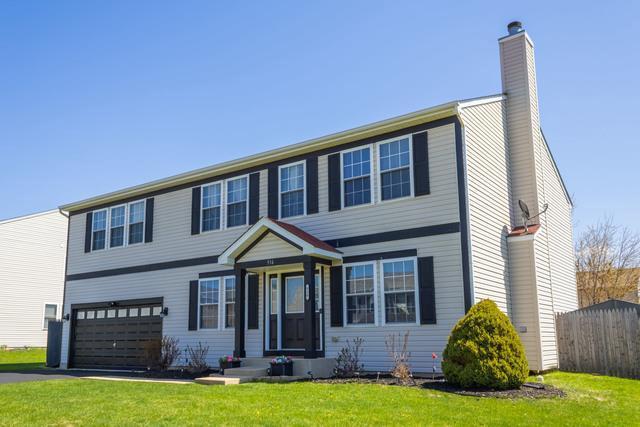 516 Prairie Point Dr, Poplar Grove, IL 61065 - view of front facade featuring a chimney, a garage, and asphalt driveway