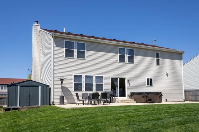 516 Prairie Point Dr, Poplar Grove, IL 61065 - rear view of property featuring a hot tub, a patio, and a chimney