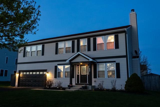 516 Prairie Point Dr, Poplar Grove, IL 61065 - view of front of home with a chimney, an attached garage, and a front lawn