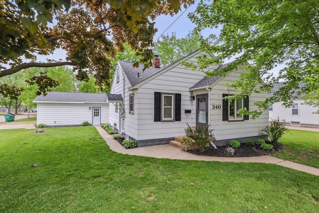 340 12th St S, Wisconsin Rapids, WI 54494 - bungalow featuring a front lawn, a shingled roof, and a chimney