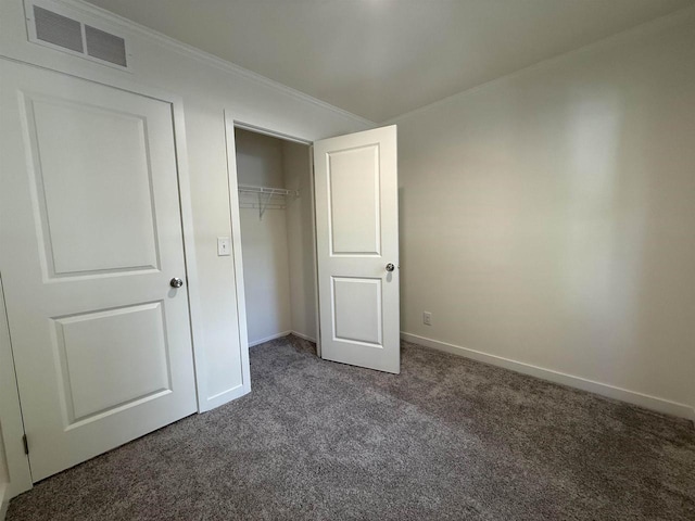 731 Sunset Blvd Unit 29, Wisconsin Dells, WI 53965 - unfurnished bedroom featuring dark colored carpet, crown molding, baseboards, and a closet