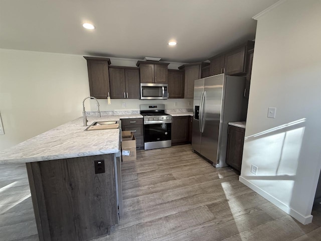 731 Sunset Blvd Unit 29, Wisconsin Dells, WI 53965 - kitchen with stainless steel appliances, a sink, dark brown cabinets, light countertops, and light wood finished floors