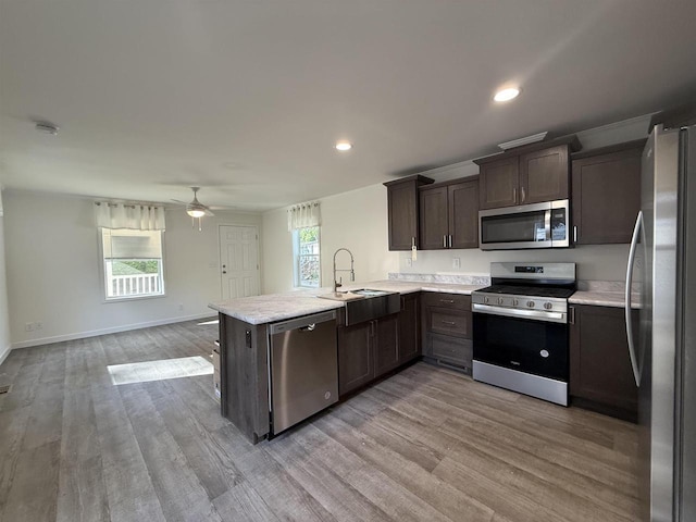 731 Sunset Blvd Unit 29, Wisconsin Dells, WI 53965 - kitchen featuring appliances with stainless steel finishes, a sink, light countertops, dark brown cabinetry, and a peninsula