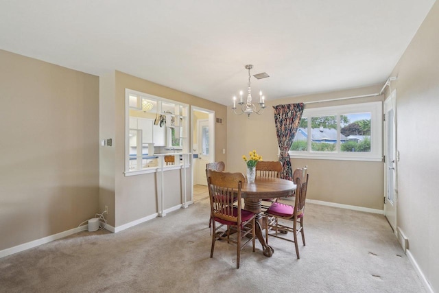 219 Summit St, Portage, WI 53901 - dining space featuring light colored carpet, a chandelier, and baseboards