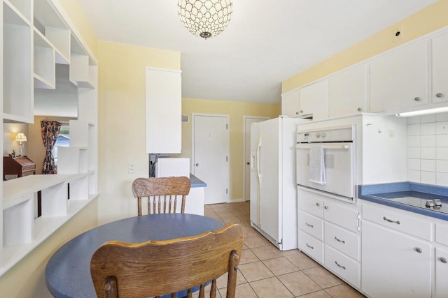 219 Summit St, Portage, WI 53901 - kitchen with white appliances, light tile patterned floors, white cabinetry, and decorative backsplash