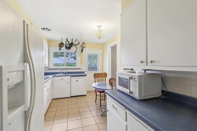 219 Summit St, Portage, WI 53901 - kitchen with white appliances, white cabinetry, dark countertops, and light tile patterned flooring