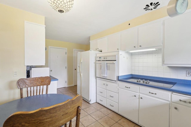 219 Summit St, Portage, WI 53901 - kitchen featuring white appliances, light tile patterned flooring, white cabinets, and backsplash