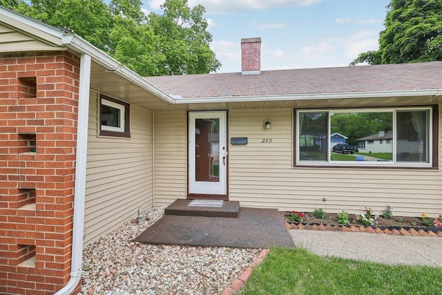 219 Summit St, Portage, WI 53901 - property entrance with a chimney and a shingled roof