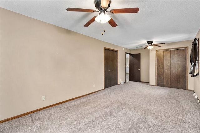 12924 Thomas St, Osseo, WI 54758 - unfurnished bedroom featuring light colored carpet, multiple closets, baseboards, a textured ceiling, and a ceiling fan
