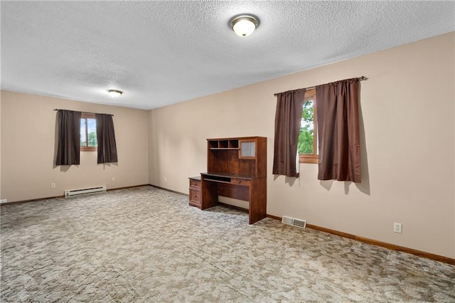 12924 Thomas St, Osseo, WI 54758 - empty room featuring a textured ceiling, a baseboard heating unit, light colored carpet, and baseboards