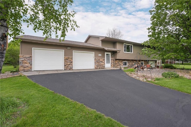 12924 Thomas St, Osseo, WI 54758 - tri-level home with stone siding, an attached garage, driveway, and a front lawn