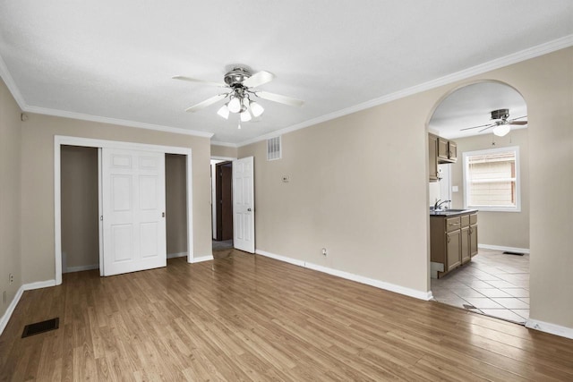 6170 N 36th St, Milwaukee, WI 53209 - unfurnished living room featuring a ceiling fan, a sink, light wood-style floors, baseboards, and ornamental molding