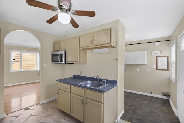 6170 N 36th St, Milwaukee, WI 53209 - kitchen featuring a sink, dark countertops, stainless steel microwave, ceiling fan, and cream cabinets